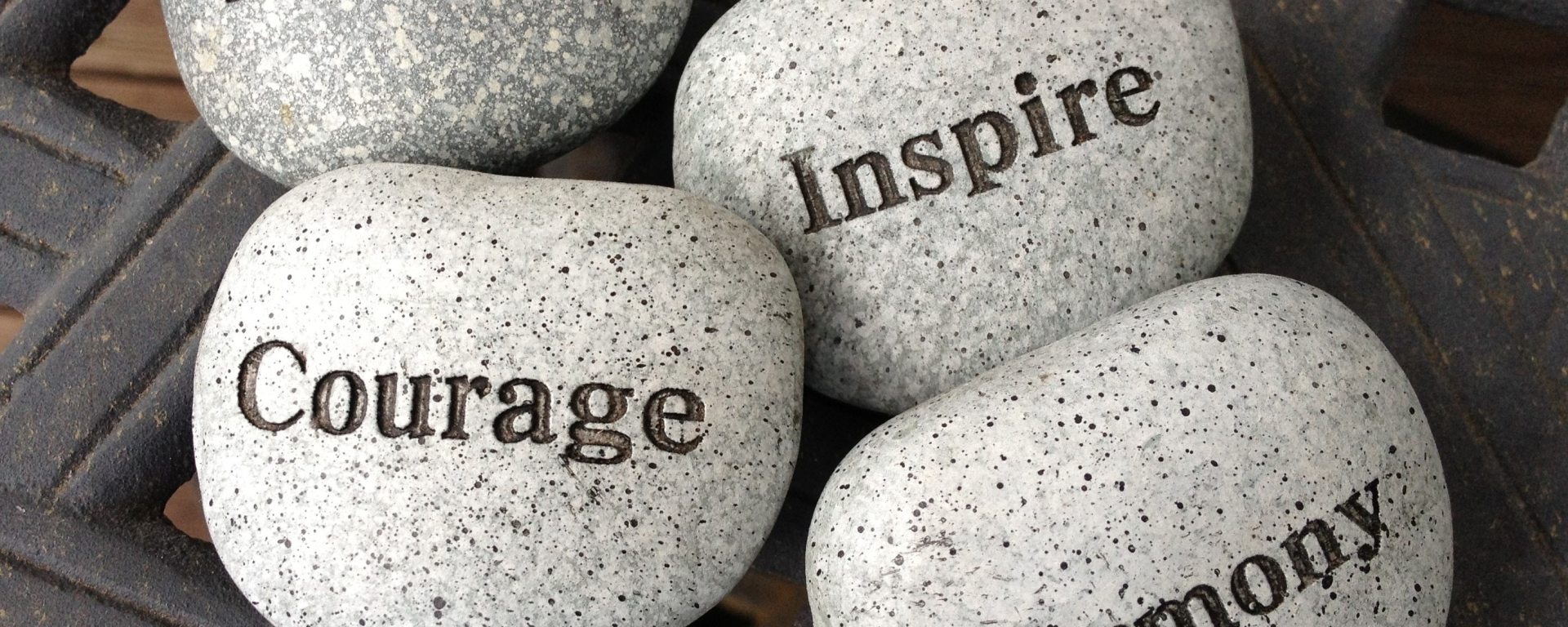 inscribed rocks saying dream courage inspire harmony on top of lattice