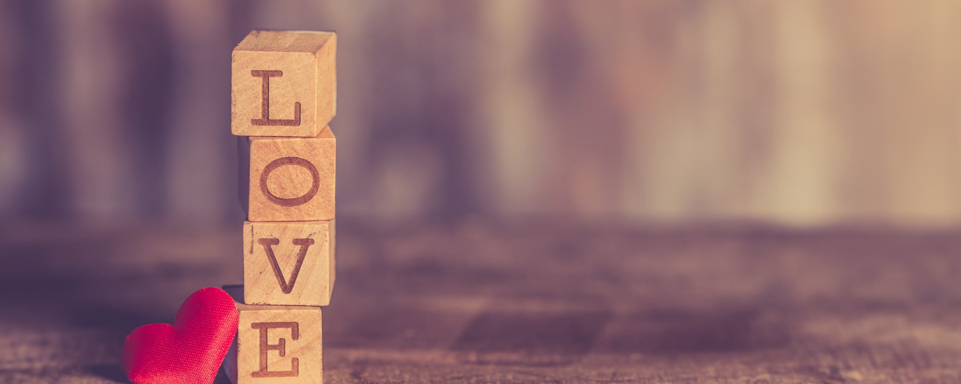 Love spelled out with letter blocks on wood floor with heart
