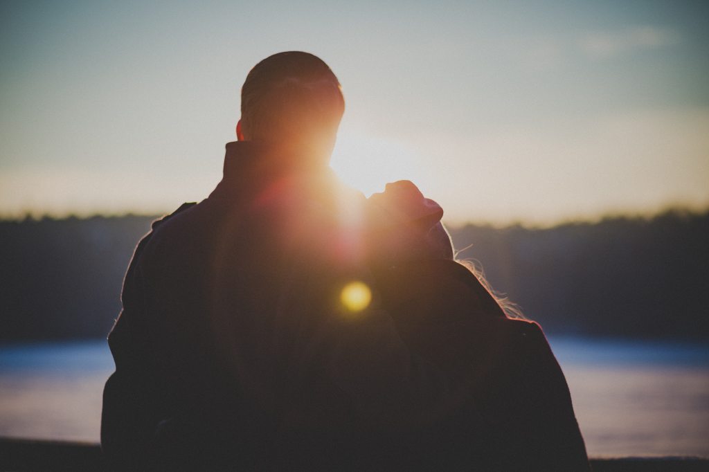 Young couple overlooking sunset on lake