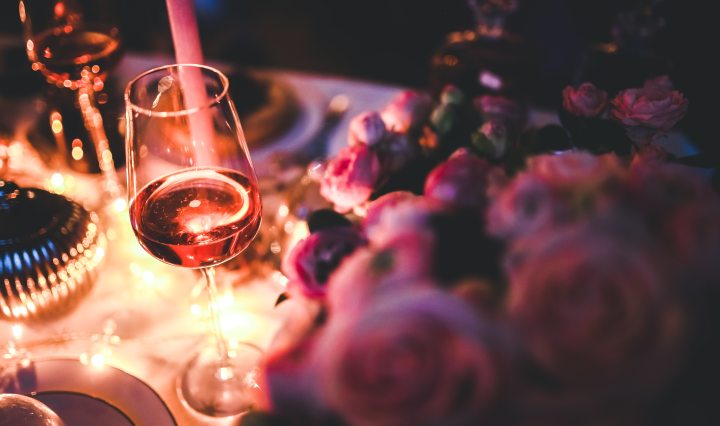 Glass of rose wine next to roses