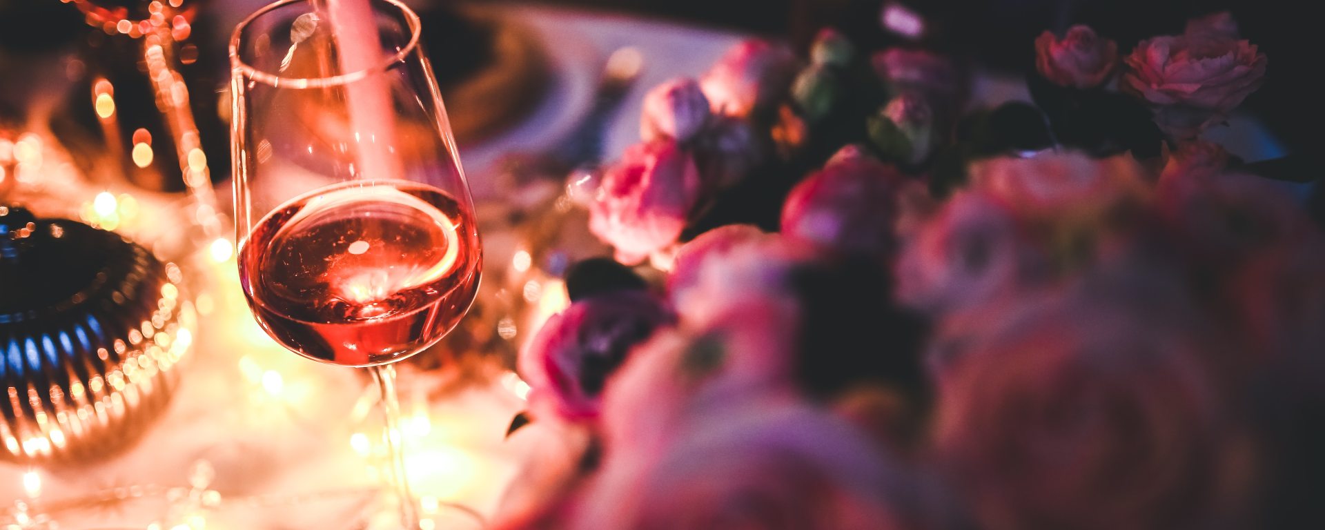 Glass of rose wine next to roses