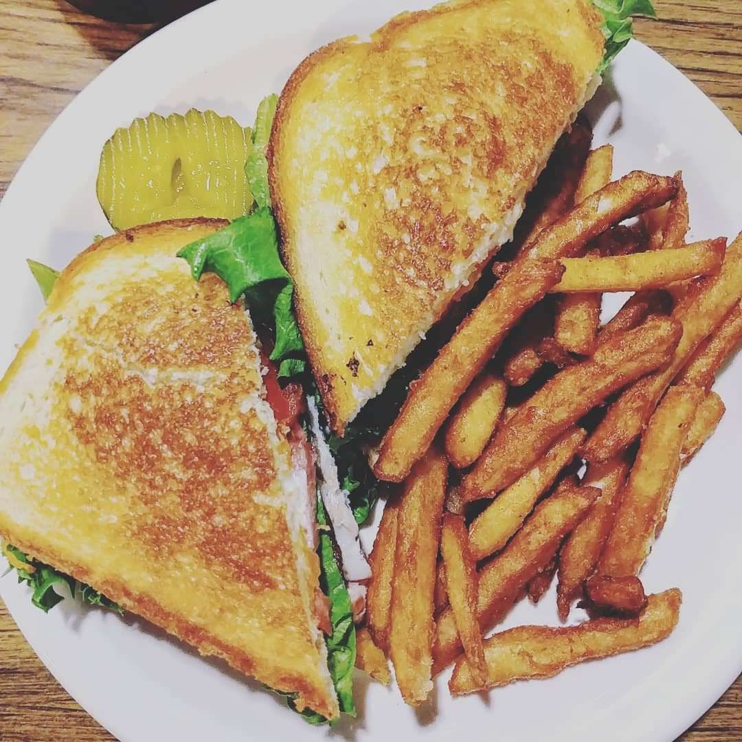 Turkey BLT with fries on white plate