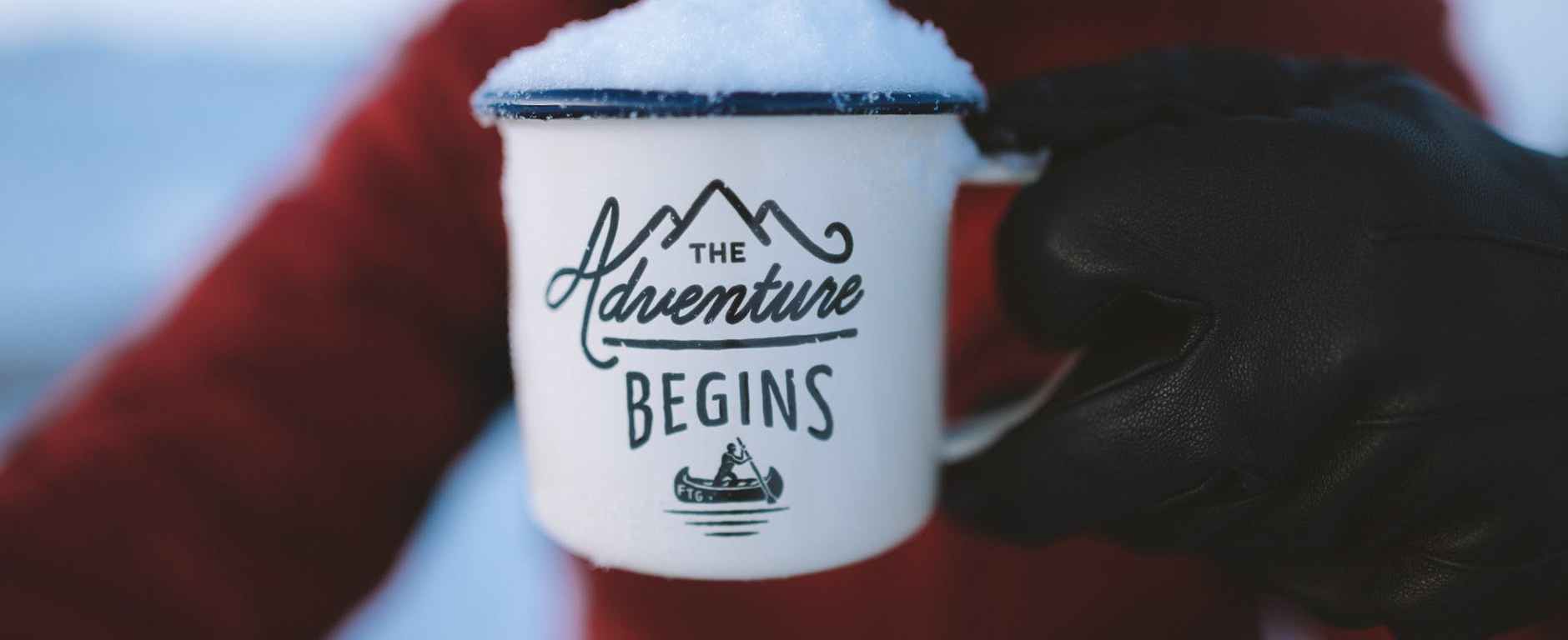 person holding the adventure begins mug