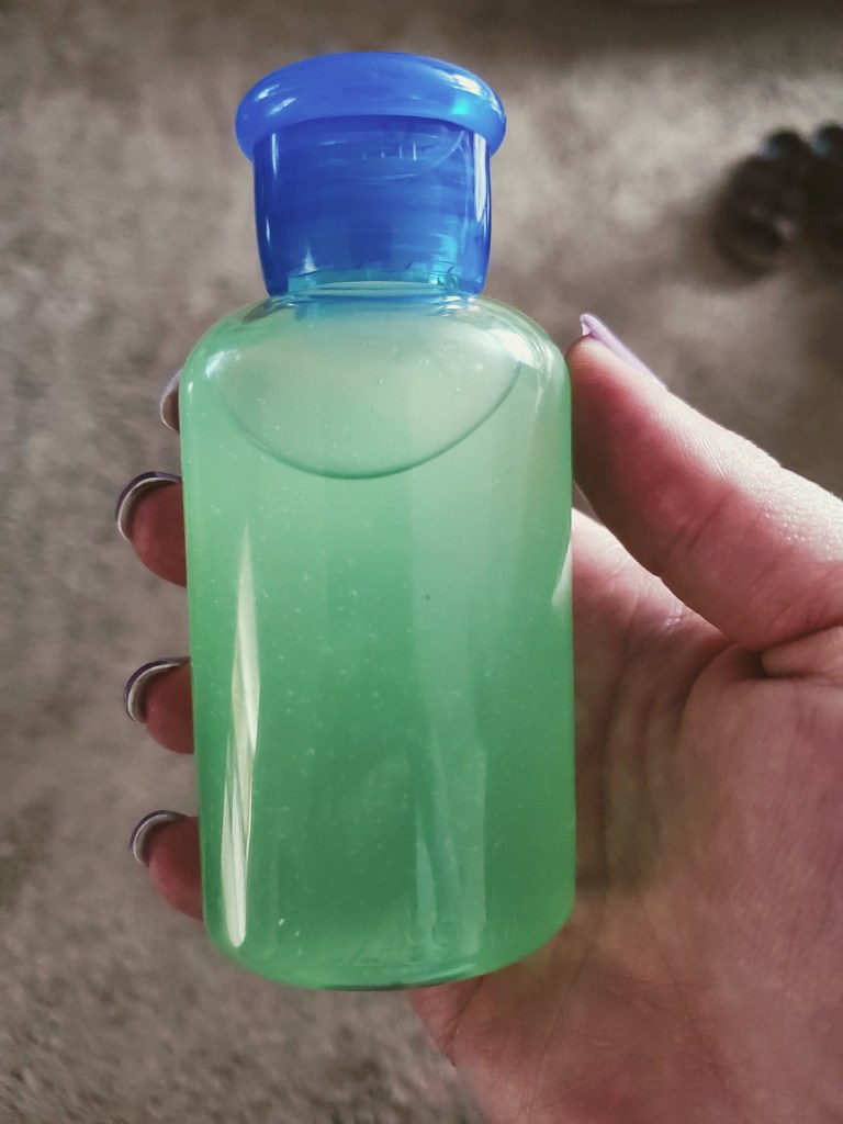 person holding hand sanitizer in bottle