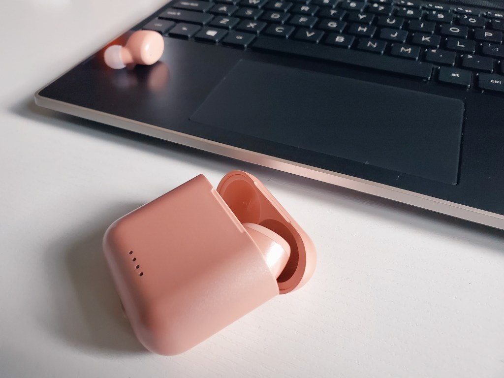 earbuds and case in front of keyboard