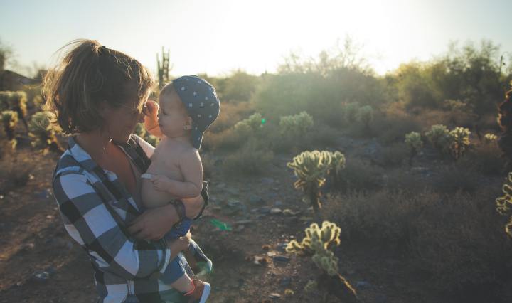 Mom holding little boy on wooded trail