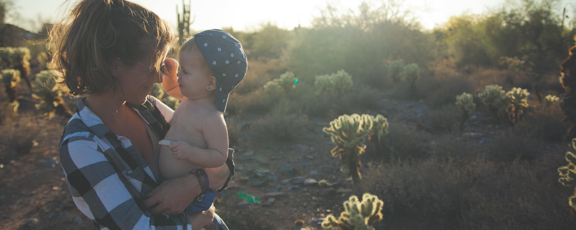 Mom holding little boy on wooded trail